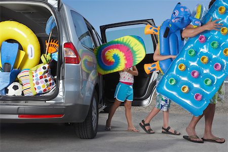 family loading car - Father and two children (6-11) unloading beach accessories from car Stock Photo - Premium Royalty-Free, Code: 693-03309313