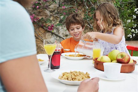 family eating cereal - Children (5-6) at table, girl pouring milk onto cereal Stock Photo - Premium Royalty-Free, Code: 693-03309392