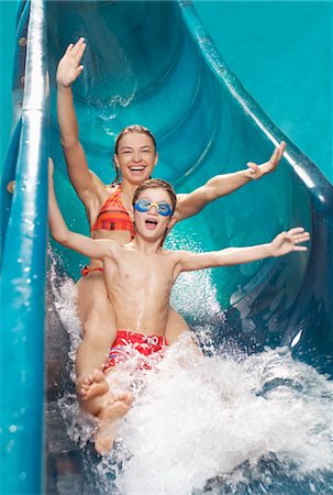 Brother and sister (7-12) with arms outstretched, on water slide Stock Photo - Premium Royalty-Free, Code: 693-03309576