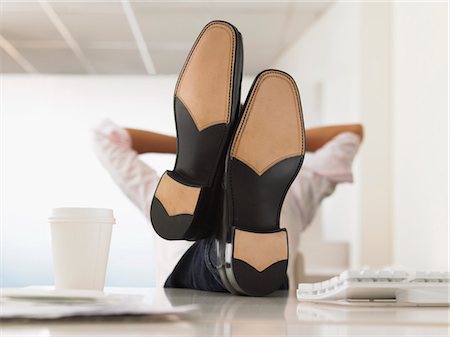 sitting with arms behind head and legs crossed - Businessman with Feet Up on Desk, obscured face Stock Photo - Premium Royalty-Free, Code: 693-03300603