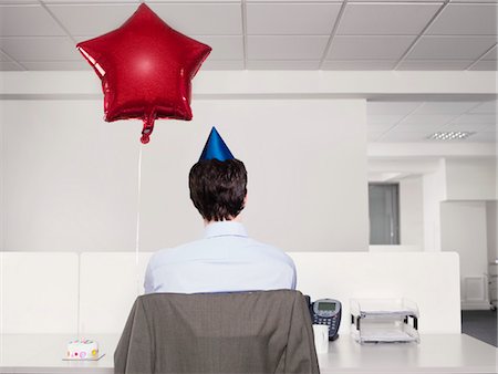 Man celebrating birthday, working alone in office Stock Photo - Premium Royalty-Free, Code: 693-03301314