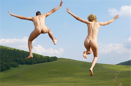 Young naked couple running and jumping in mountain field, back view Stock Photo - Premium Royalty-Free, Code: 693-03301627