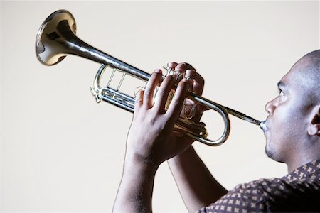 picture of the blue playing a instruments - Trumpeter playing, looking up, close-up, side view Stock Photo - Premium Royalty-Free, Code: 693-03302069
