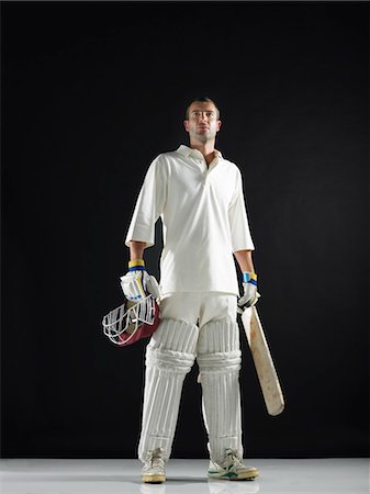 Cricket player, standing holding cricket bat, low angle view Stock Photo - Premium Royalty-Free, Code: 693-03302989