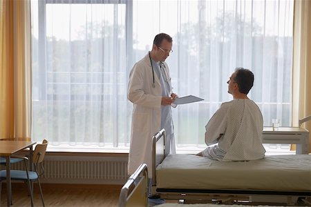 patient standing in hospital room - Doctor talking to Patient in Hospital Room, back view of patient Stock Photo - Premium Royalty-Free, Code: 693-03303147