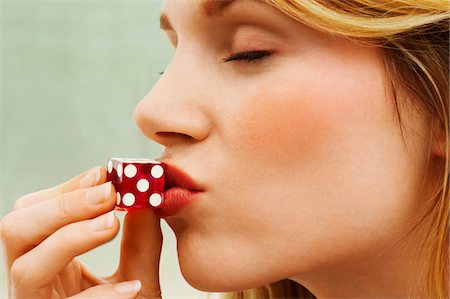 dice - Woman Kissing Dice, close up, side view Stock Photo - Premium Royalty-Free, Code: 693-03303142