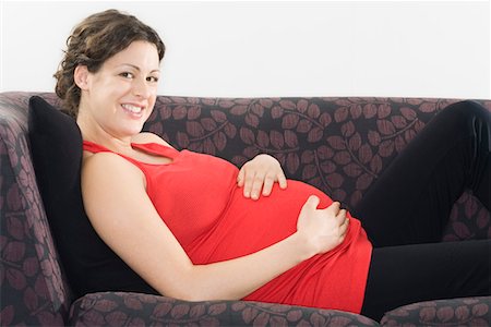 female belly expansion - Pregnant woman relaxing on sofa, portrait Stock Photo - Premium Royalty-Free, Code: 693-03314529