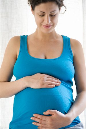 female belly expansion - Pregnant woman holding stomach Stock Photo - Premium Royalty-Free, Code: 693-03314557