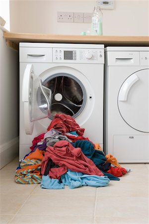 Pile of clothes in front of washing machine Stock Photo - Premium Royalty-Free, Code: 693-03314646