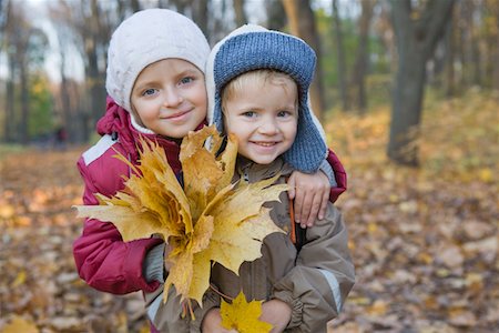 sister brother hugging two - Brother and sister holding leaves in park, portrait Stock Photo - Premium Royalty-Free, Code: 693-03315250