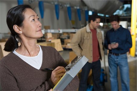 Femme asiatique, prendre des notes dans l'entrepôt de distribution Photographie de stock - Premium Libres de Droits, Code: 693-03315315