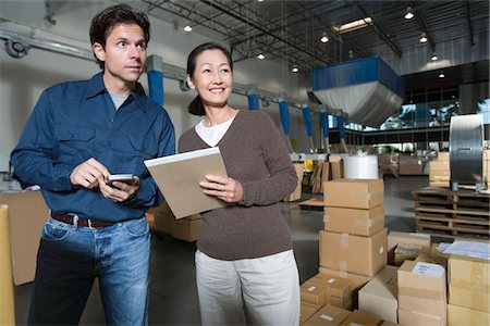Homme et femme dans l'entrepôt de distribution Photographie de stock - Premium Libres de Droits, Code: 693-03315312