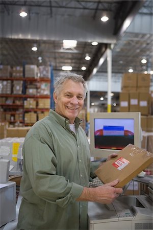 simsearch:693-03315348,k - Cheerful man working in distribution warehouse Foto de stock - Sin royalties Premium, Código: 693-03315336