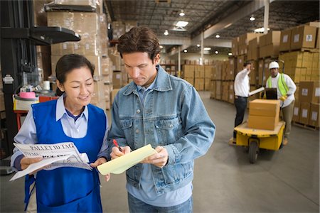 Woman and man talking in distribution warehouse Stock Photo - Premium Royalty-Free, Code: 693-03315332