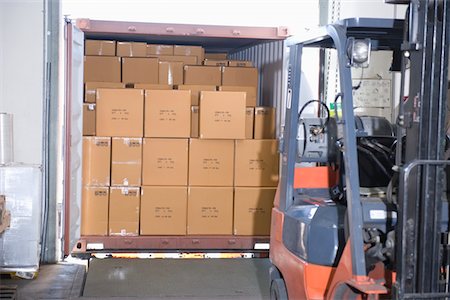 distribution warehouse - Cardboard boxes and fork lift truck in distribution warehouse Stock Photo - Premium Royalty-Free, Code: 693-03315352