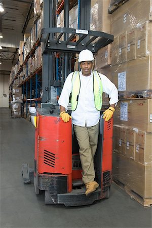 simsearch:693-03315348,k - Man standing with fork lift truck in distribution warehouse Foto de stock - Sin royalties Premium, Código: 693-03315386