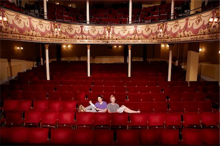 Young women sitting in theatre stalls Stock Photo - Premium Royalty-Free, Code: 693-03316958