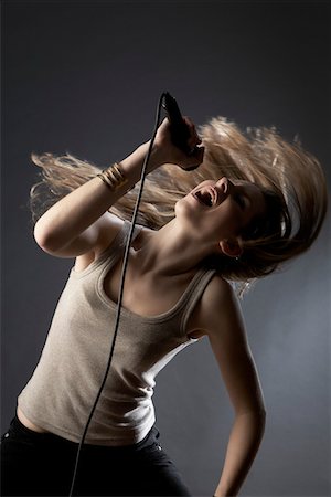 singers - Young woman singing in studio Foto de stock - Sin royalties Premium, Código: 693-03311028