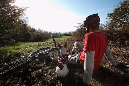 dog bike - Mountain biker and dog sitting beside bike in countryside Stock Photo - Premium Royalty-Free, Code: 693-03311239