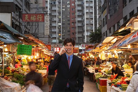 Young business man talking on mobile at street market Stock Photo - Premium Royalty-Free, Code: 693-03311609