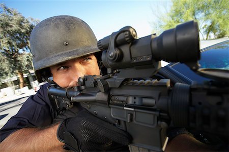 Portrait of Swat officer aiming gun Stock Photo - Premium Royalty-Free, Code: 693-03312329