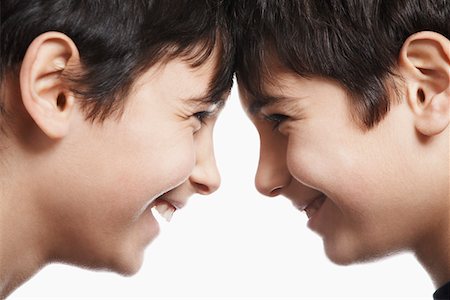 Twin boys (13-15) head to head, laughing, close-up Stock Photo - Premium Royalty-Free, Code: 693-03312731