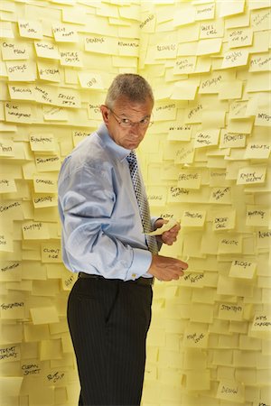 self adhesive note - Businessman at Wall with Post Its Stock Photo - Premium Royalty-Free, Code: 693-03440754