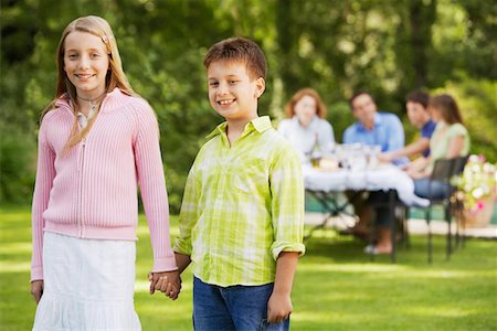 Brother and Sister Holding Hands in back yard, portrait Stock Photo - Premium Royalty-Free, Code: 693-03557167