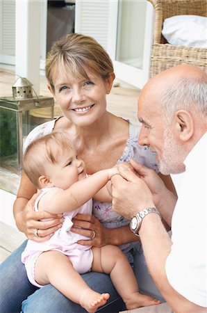 Grandparents playing with granddaughter on porch Stock Photo - Premium Royalty-Free, Code: 693-03565058