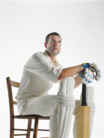 Cricket player sitting in chair, holding cricket bat, side view Stock Photo - Premium Royalty-Free, Code: 693-03565398