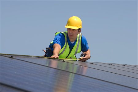 solar panel usa - Maintenance worker measures solar array on rooftop, Los Angeles, California Stock Photo - Premium Royalty-Free, Code: 693-03643967