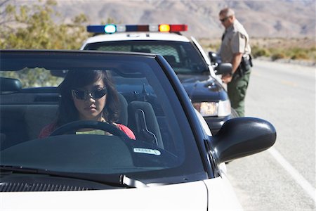 Women sitting in car being pulled over by police officer Stock Photo - Premium Royalty-Free, Code: 693-03686514