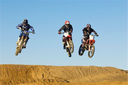 simsearch:6115-06778762,k - Trois coureurs de motocross dans les airs Photographie de stock - Premium Libres de Droits, Code: 693-03707258