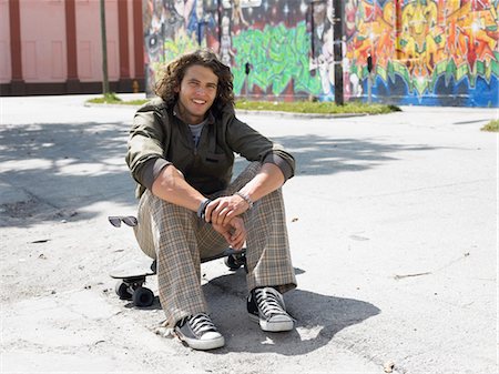 simsearch:693-03363602,k - Young man sitting on skateboard, outdoors, portrait Stock Photo - Premium Royalty-Free, Code: 693-03707422
