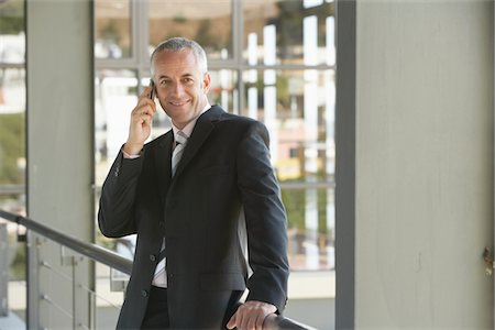 simsearch:400-05366591,k - Businessman Using Cell Phone in Office Stock Photo - Premium Royalty-Free, Code: 693-03707831