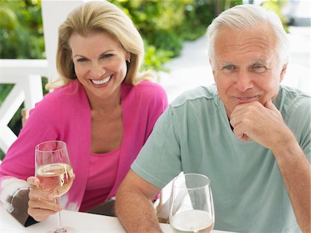 Couple holding wine glasses, sitting at verandah table, elevated view Foto de stock - Sin royalties Premium, Código: 693-03707893