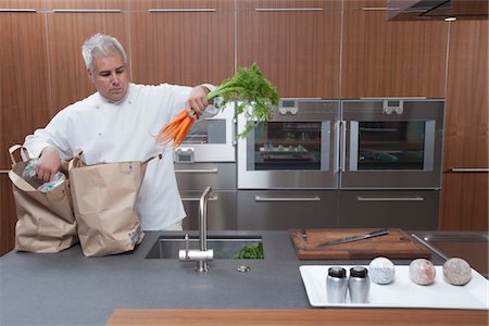 Mid- adult chef lifting carrots into sink Stock Photo - Premium Royalty-Free, Code: 693-03782507