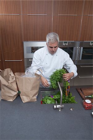 Mid- adult chef washing leaf vegetables in sink Stock Photo - Premium Royalty-Free, Code: 693-03782510