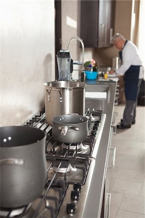 Chef works in kitchen with saucepans on hob Stock Photo - Premium Royalty-Free, Code: 693-03782556