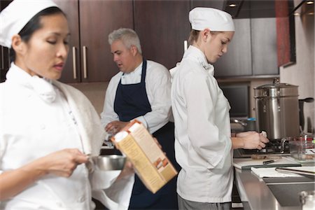 Three chefs work together in busy kitchen Stock Photo - Premium Royalty-Free, Code: 693-03782565