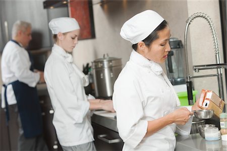 Three chefs work side by side in busy kitchen Stock Photo - Premium Royalty-Free, Code: 693-03782566