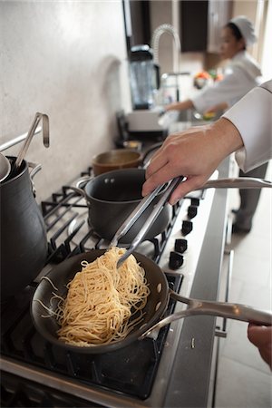 Heating spaghettin on a hob Stock Photo - Premium Royalty-Free, Code: 693-03782571