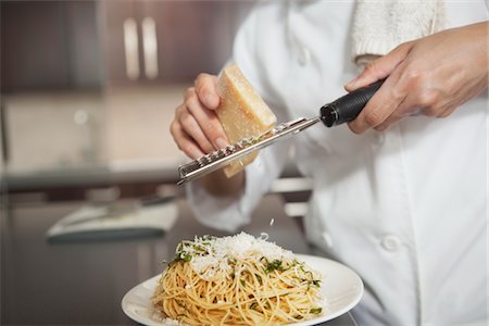 Grating parmesan onto spaghetti Stock Photo - Premium Royalty-Free, Code: 693-03782572