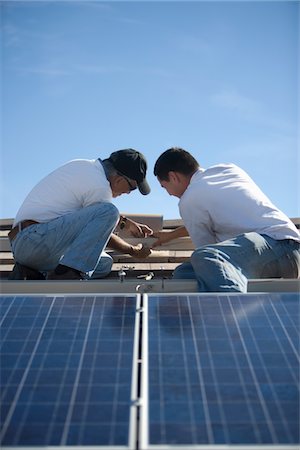 simsearch:693-03643971,k - Two people on a rooftop working on solar panelling Stock Photo - Premium Royalty-Free, Code: 693-03782697