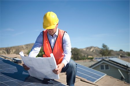 simsearch:693-03643971,k - A business man on a solar panalled rooftop looking at plans Stock Photo - Premium Royalty-Free, Code: 693-03782693