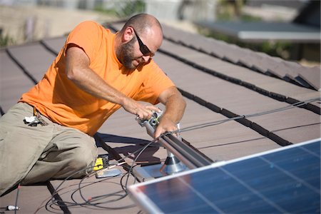 simsearch:693-03643971,k - One man working on solar panelling on a roof top Stock Photo - Premium Royalty-Free, Code: 693-03782707