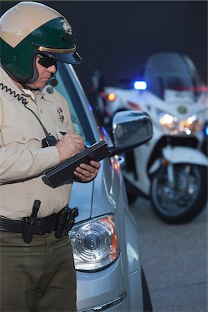 police officer (male) - Patrol officer stands witing ticket Stock Photo - Premium Royalty-Free, Code: 693-03782762