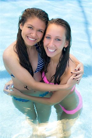 Two Teenage Girls Hugging in Swimming Pool Foto de stock - Con derechos protegidos, Código: 700-04163454