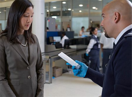 southern european descent - Security Guard Removing Prohibited Item from Woman's Bag at Airport Stock Photo - Rights-Managed, Code: 700-05821721