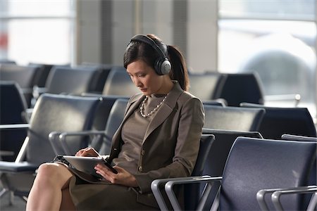 Femme d'affaires avec ordinateur tablette dans l'aéroport Photographie de stock - Rights-Managed, Code: 700-05821769